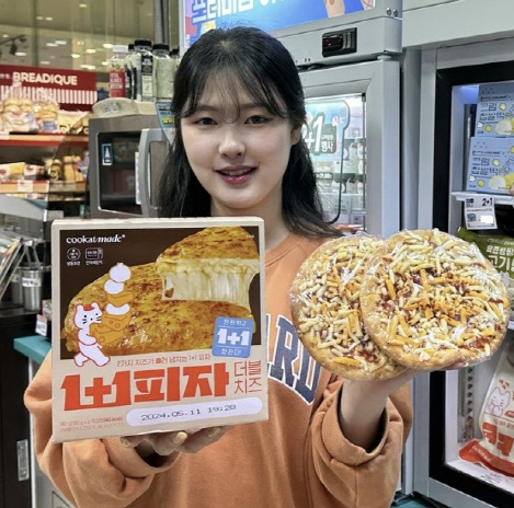 모델이 GS25에서 'ㅃ피자'를 소개하고 있다. GS25 제공